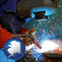 alaska an industrial welder wearing a welding helmet and safety gloves