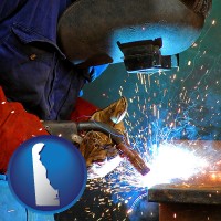 delaware an industrial welder wearing a welding helmet and safety gloves