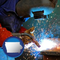 iowa an industrial welder wearing a welding helmet and safety gloves