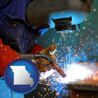 missouri an industrial welder wearing a welding helmet and safety gloves