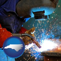 north-carolina an industrial welder wearing a welding helmet and safety gloves