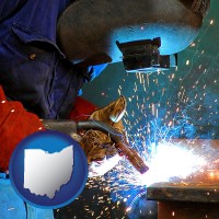 ohio an industrial welder wearing a welding helmet and safety gloves