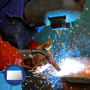 an industrial welder wearing a welding helmet and safety gloves - with North Dakota icon