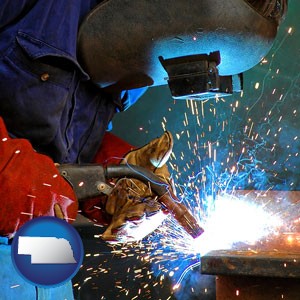 an industrial welder wearing a welding helmet and safety gloves - with Nebraska icon
